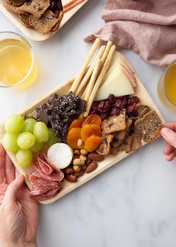 Charcuterie board with cheese, meats, grapes, and wine at Pindar Vineyards.