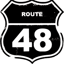 Aluminum Route 48 road sign at Pindar Vineyards during live music event.