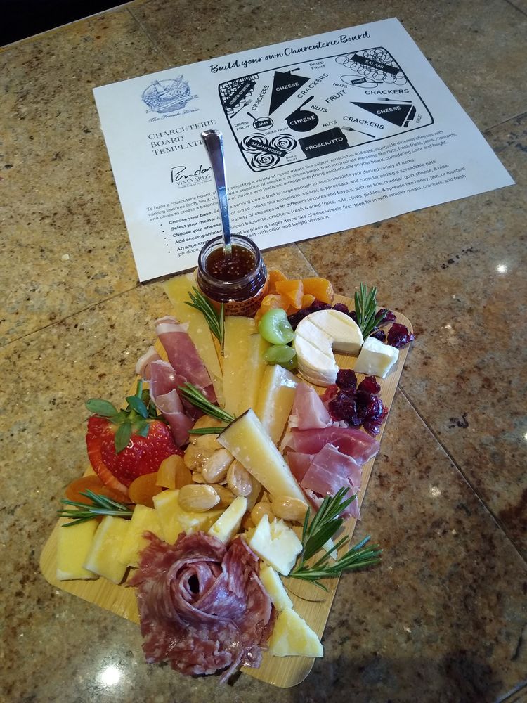 Charcuterie board with cheese, meats, fruits, and crackers for wine tasting.