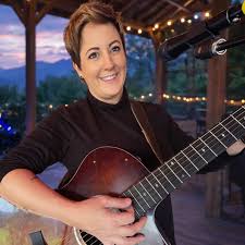 Sunset Fridays at Pindar Vineyards with Erin Chase playing guitar outdoors.
