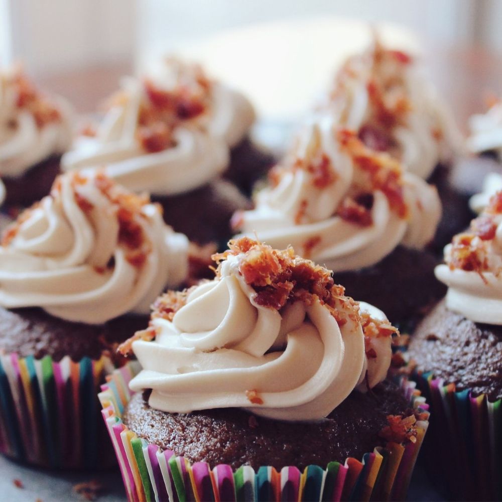 Chocolate cupcakes with vanilla frosting and sprinkles, perfect for dessert or special occasions.