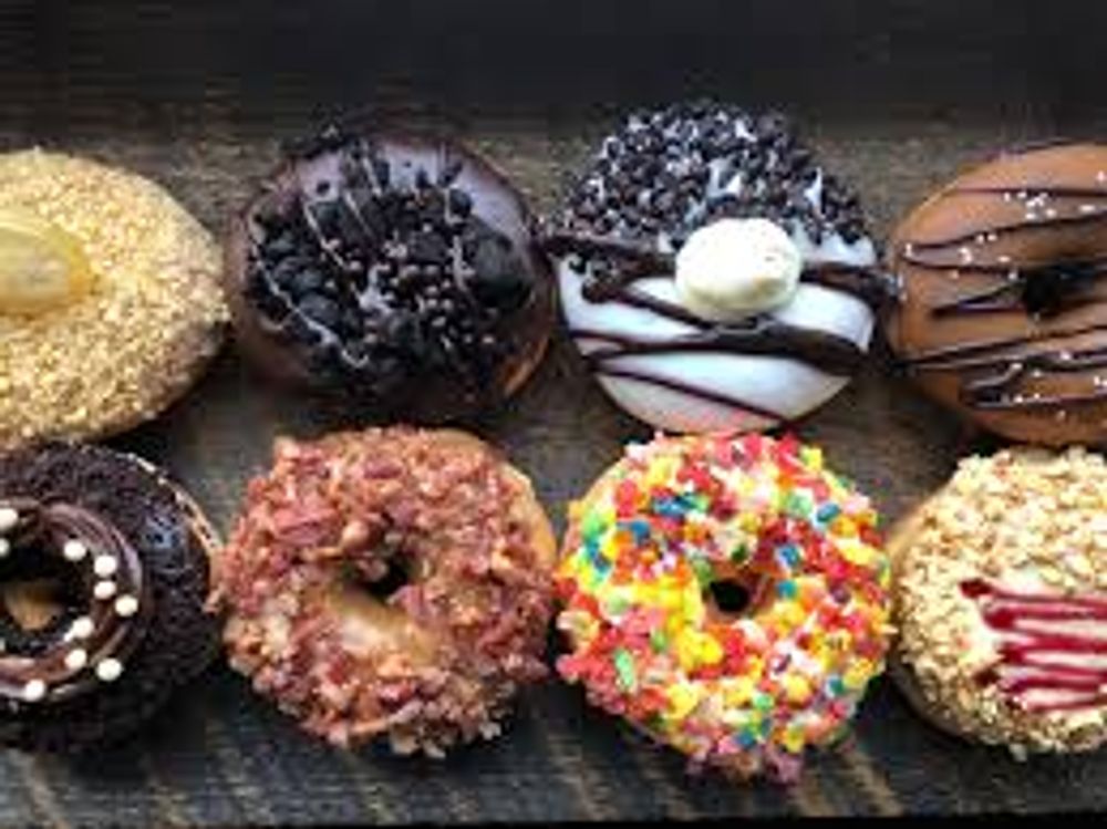 Delicious assortment of donuts featuring chocolate, sprinkles, and icing, perfect for a sweet treat or dessert.