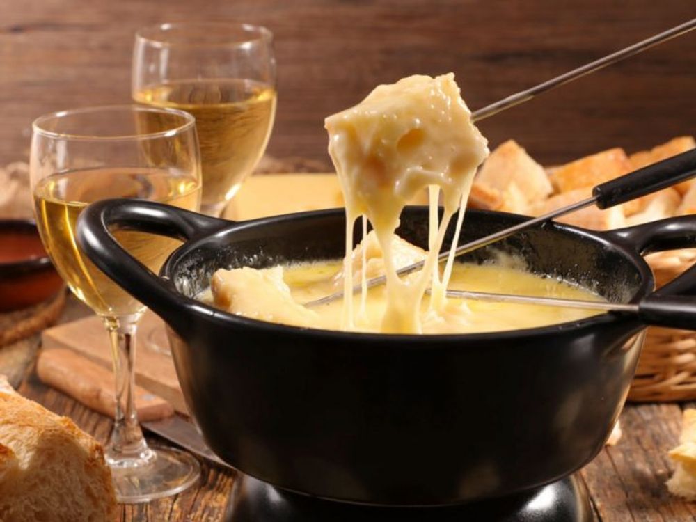 Delicious cheese fondue served with two glasses of white wine at Pindar Vineyards. Perfect for wine and cheese lovers.